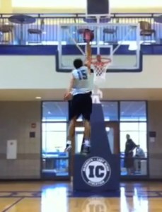 Basket-ball player jumbing to drop the ball in the basket.