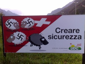 Click on the picture to view it in its original context Same poster as above, but in Italian, with svastikas added on the white sheep who kick out the black sheep
